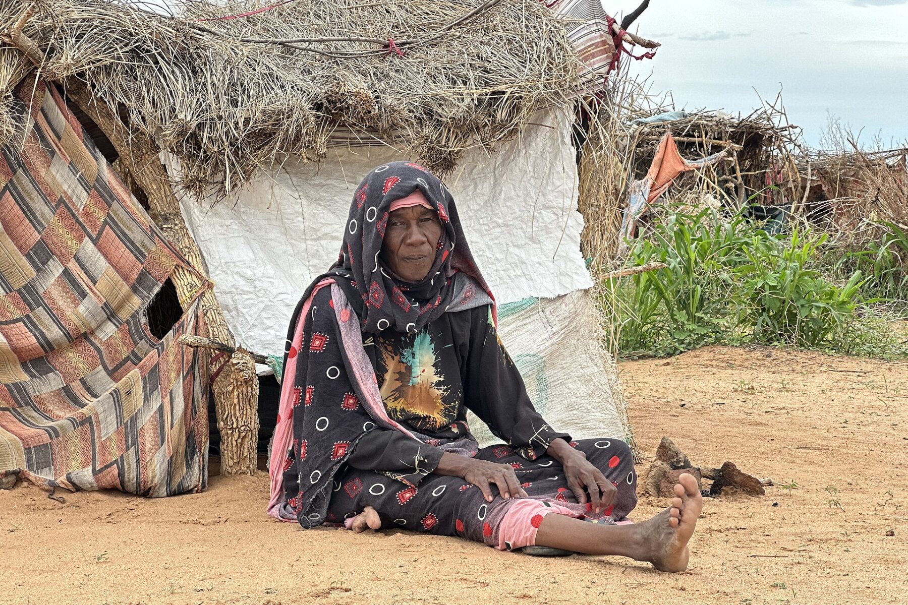A displaced Sudanese woman sheltering with cloth in Darfur