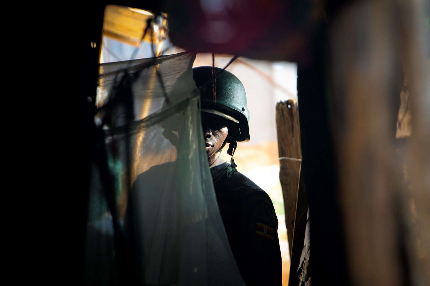 Ugandan soldier in helmet, partially obscured