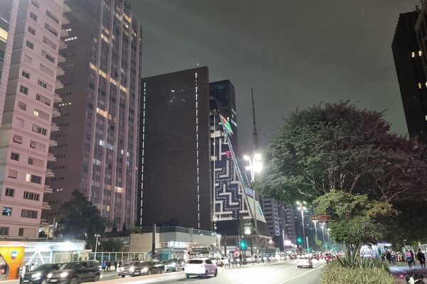 São Paulo nightlife: Avenida Paulista at night, with traffic and the lit facade of the FIESP building