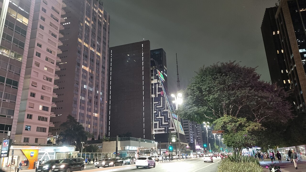 São Paulo nightlife: Avenida Paulista at night, with traffic and the lit facade of the FIESP building