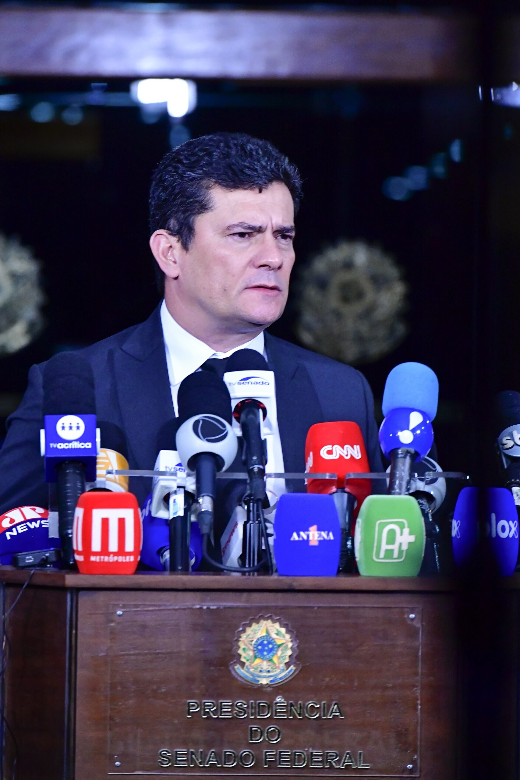 Senator Sergio Moro speaks into a bank of television microphones at a press conference in Brasília