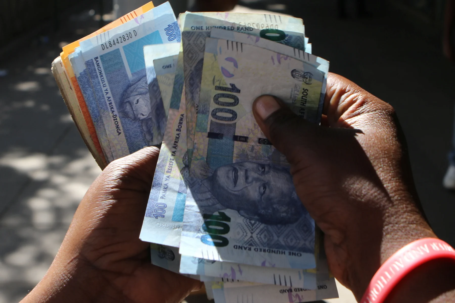 Hands holding South African Rand banknotes