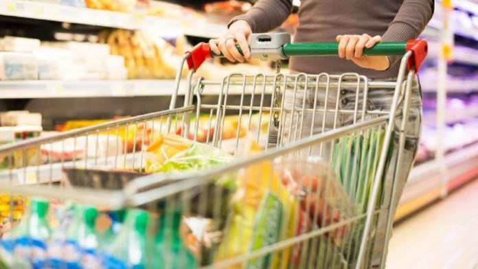 A shopper pushes a cart through a Brazilian supermarket aisle; food prices are the second-biggest line in expat budgets after rent