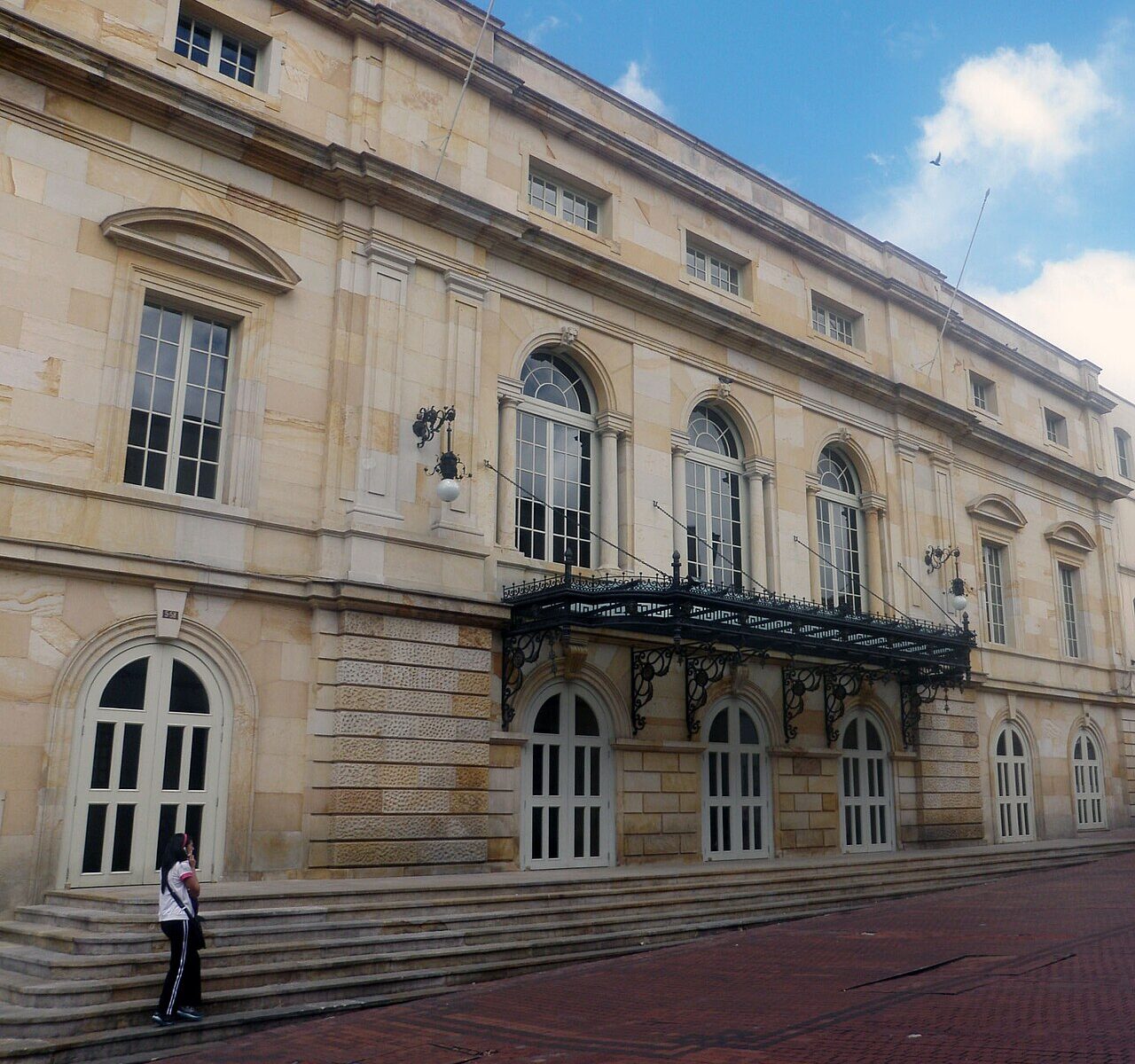 Facade of the historic Teatro Colón theater in downtown Bogotá, with arched windows and a wrought-iron balcony
