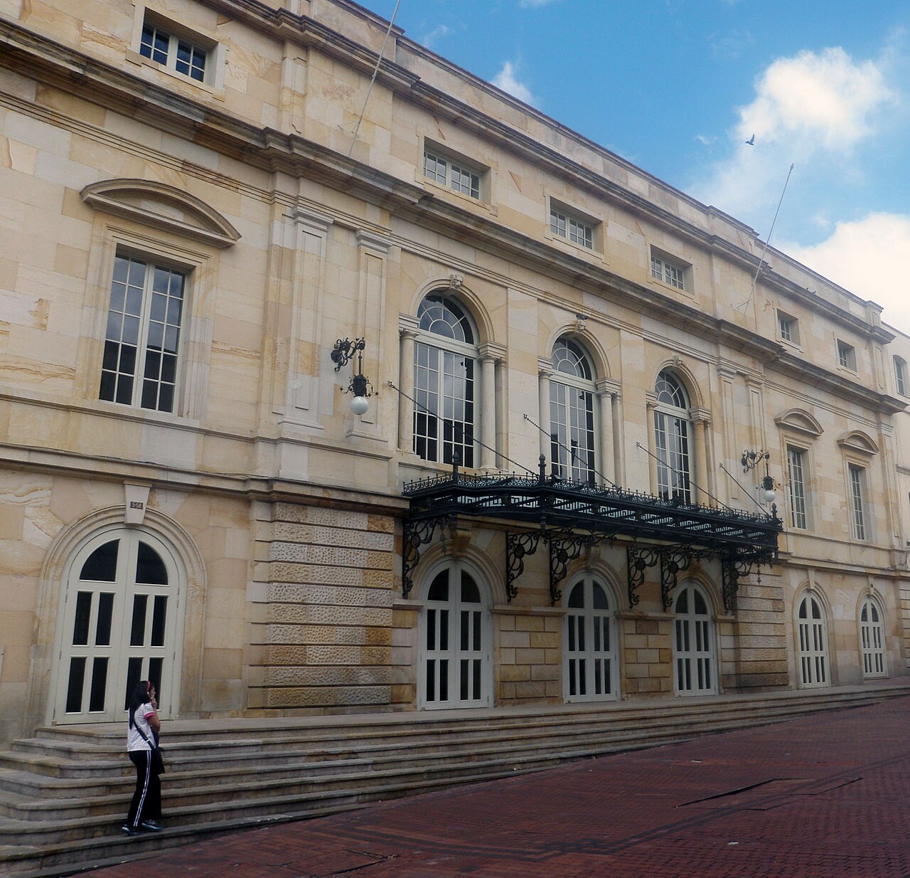 Facade of the historic Teatro Colón theater in downtown Bogotá, with arched windows and a wrought-iron balcony