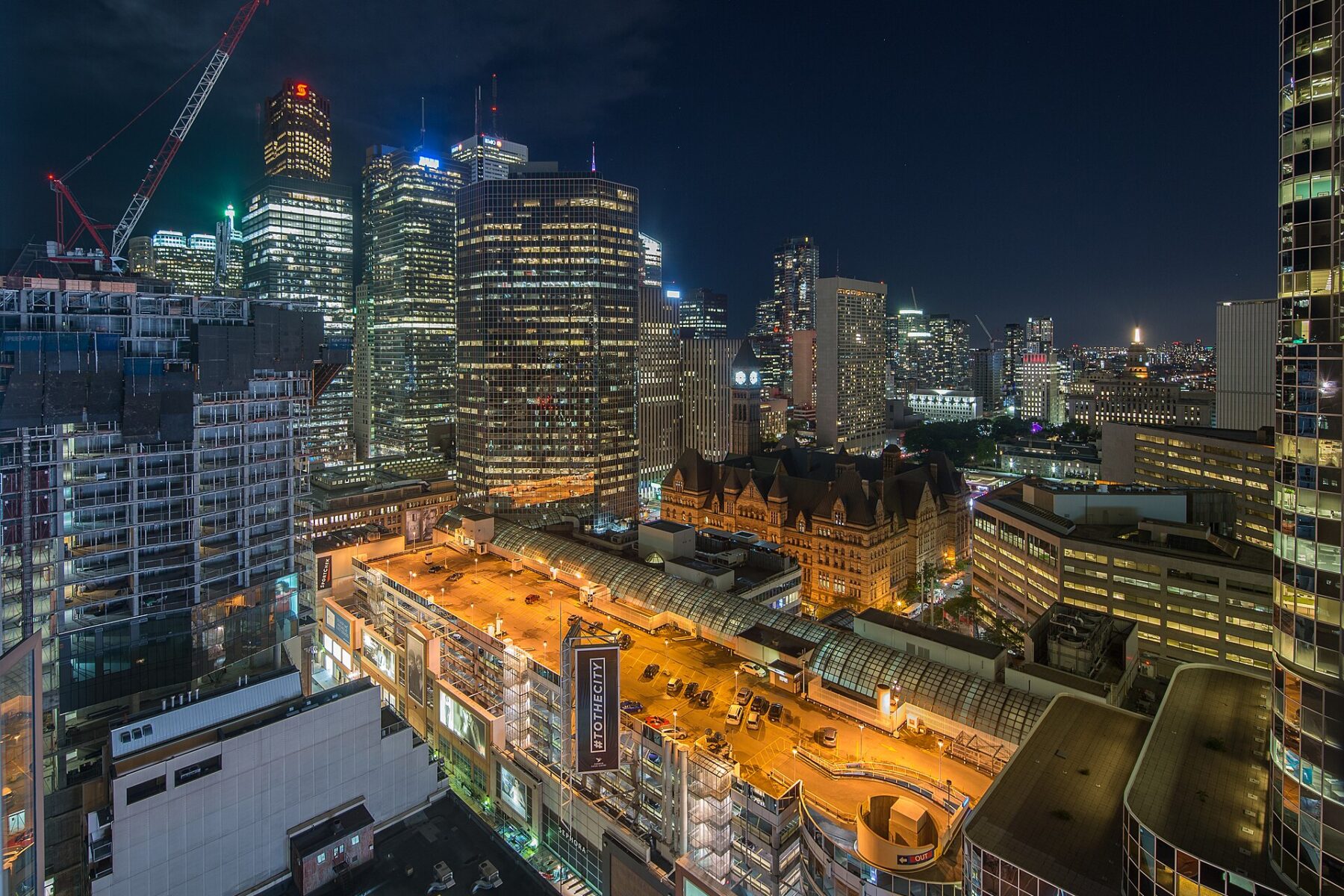 Skyscrapers and lit streets of Toronto's financial district at night.