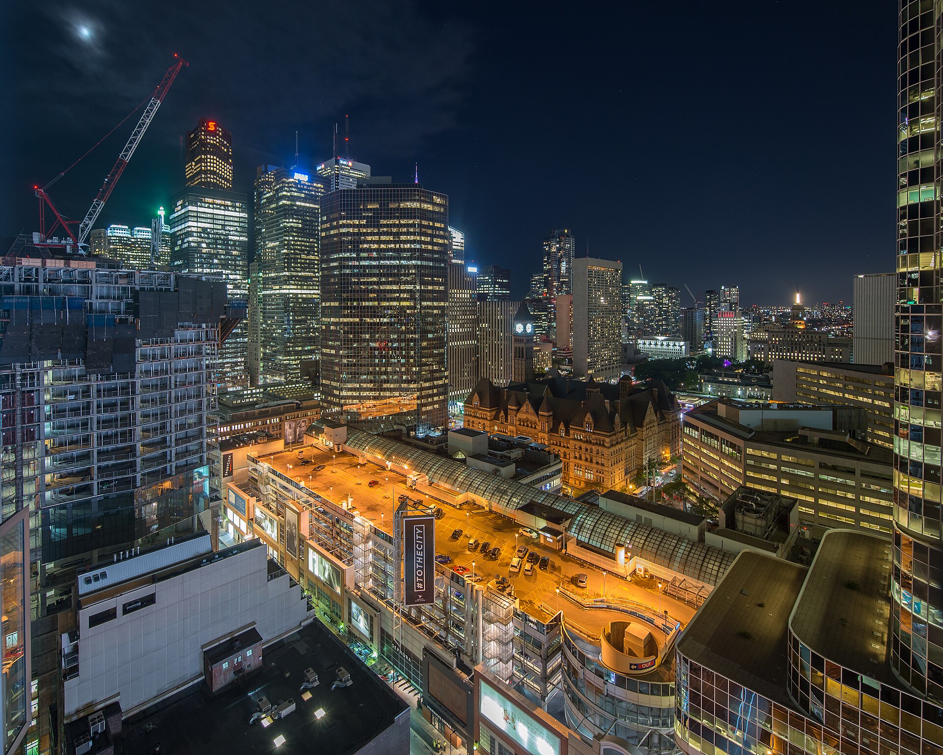 Bank towers in Toronto’s financial district lit at night above the city’s older civic buildings