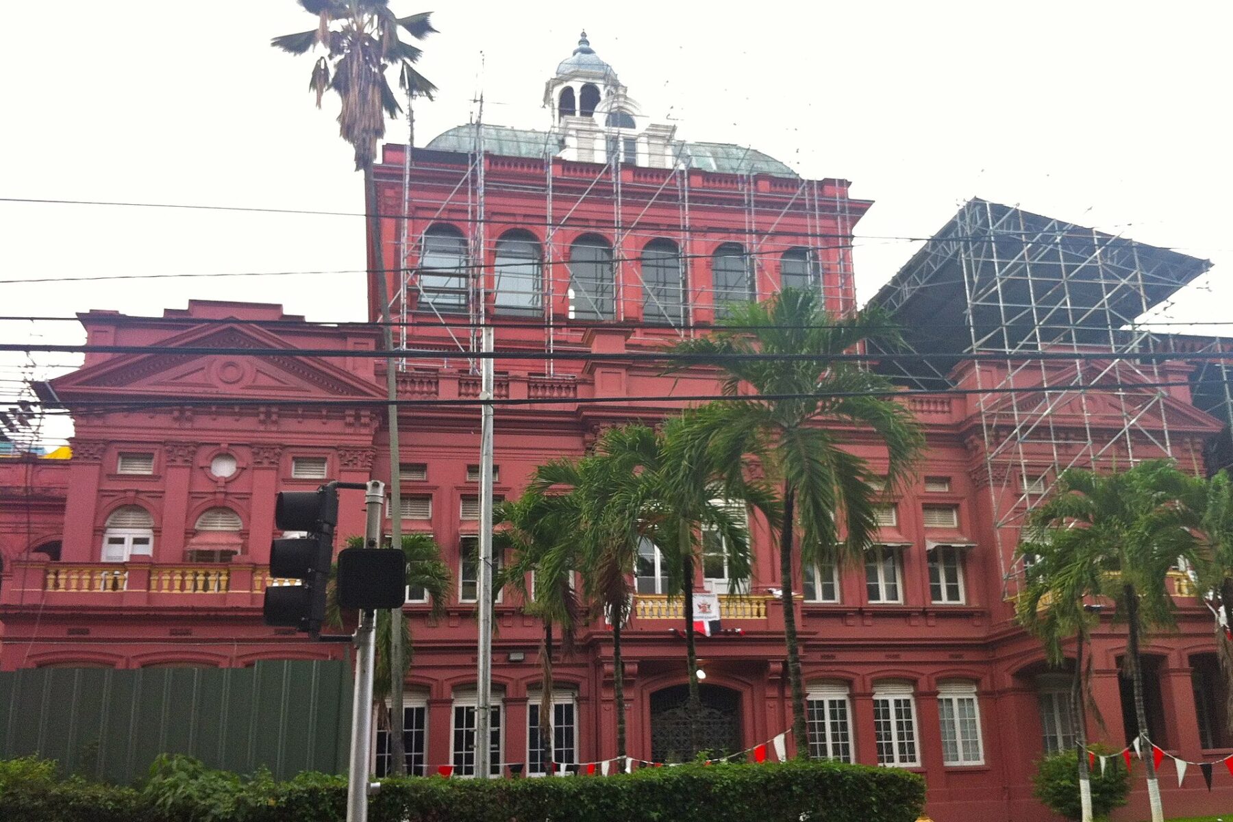 The Red House, Trinidad and Tobago's parliament building in Port of Spain, with scaffolding on its upper floors and palm trees in front
