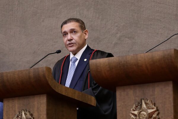 Kassio Nunes Marques in judicial robes speaking at a lectern at his inauguration as president of Brazil's electoral court, the judge behind the Lula radio ad suspension