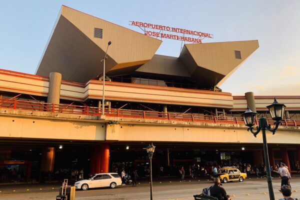 Cuba travel advice: Terminal 3 of José Martí International Airport in Havana, with an official yellow taxi and travellers outside