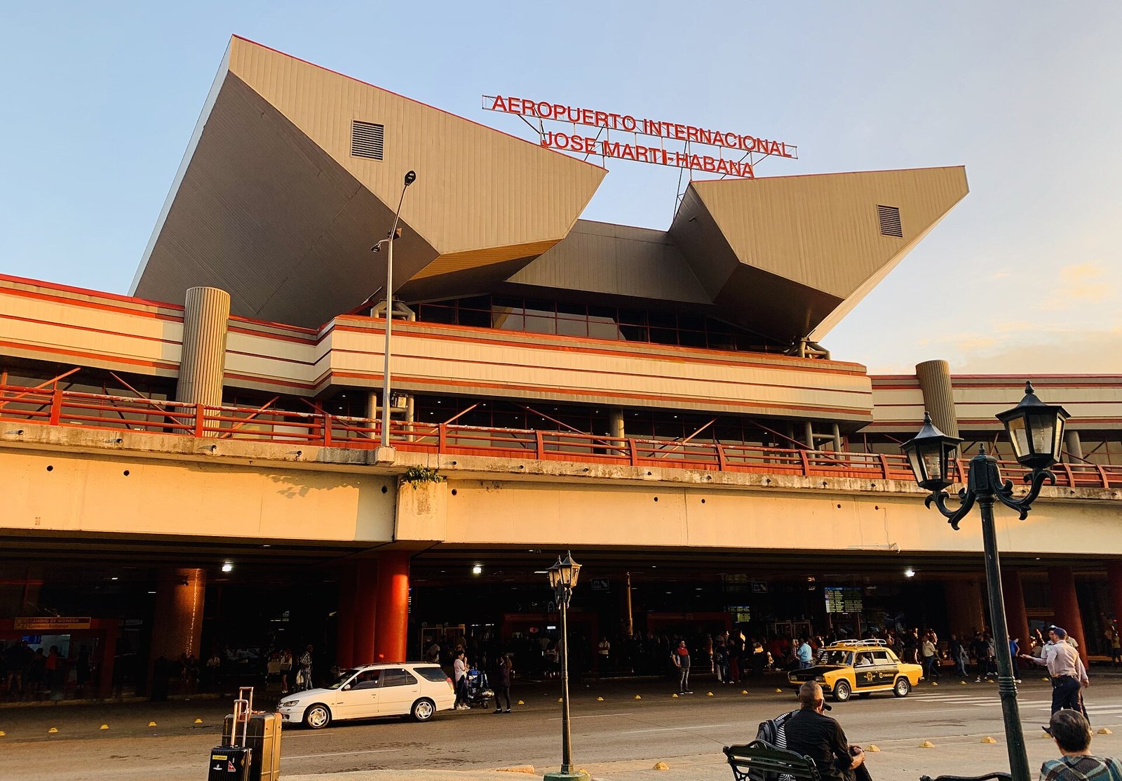 Cuba travel advice: Terminal 3 of José Martí International Airport in Havana, with an official yellow taxi and travellers outside