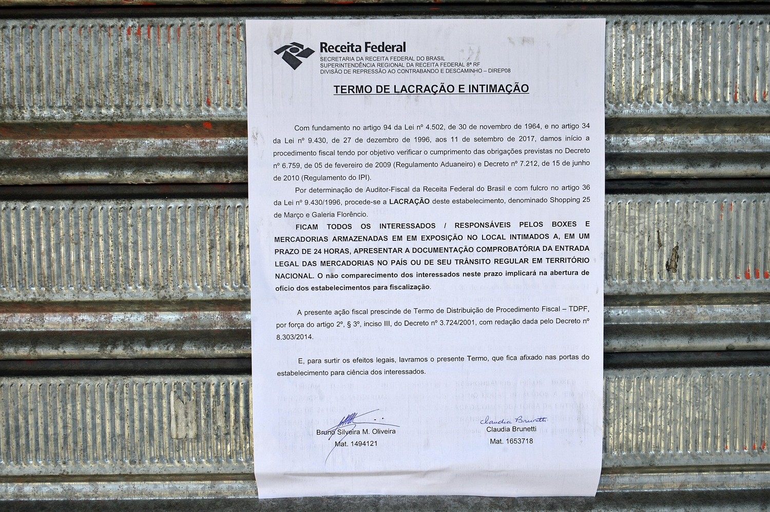 A federal tax authority sealing notice taped to the shutter of a closed shop in Sao Paulo