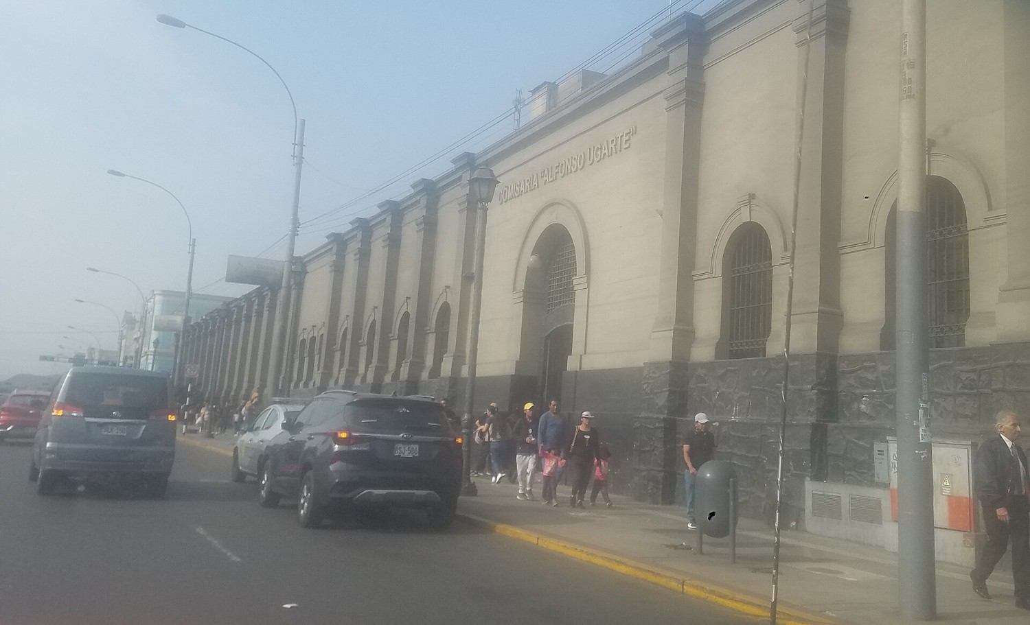 A large stone institutional building beside a road in Lima, Peru