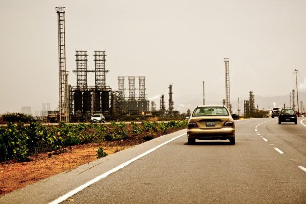 Oil refinery with cars on a highway