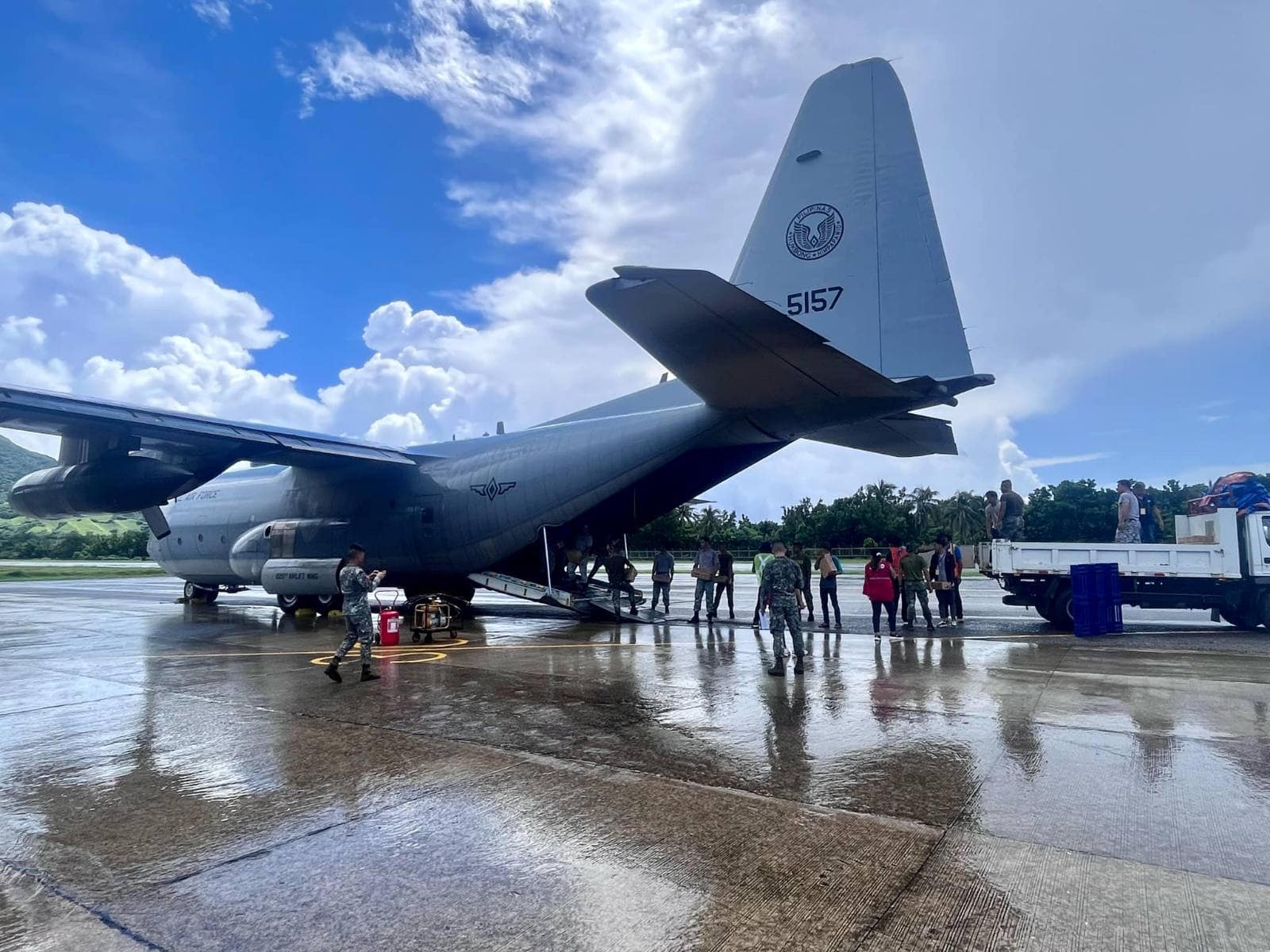 A Philippine Air Force C-130 transport aircraft parked on a wet airfield apron in Batanes.