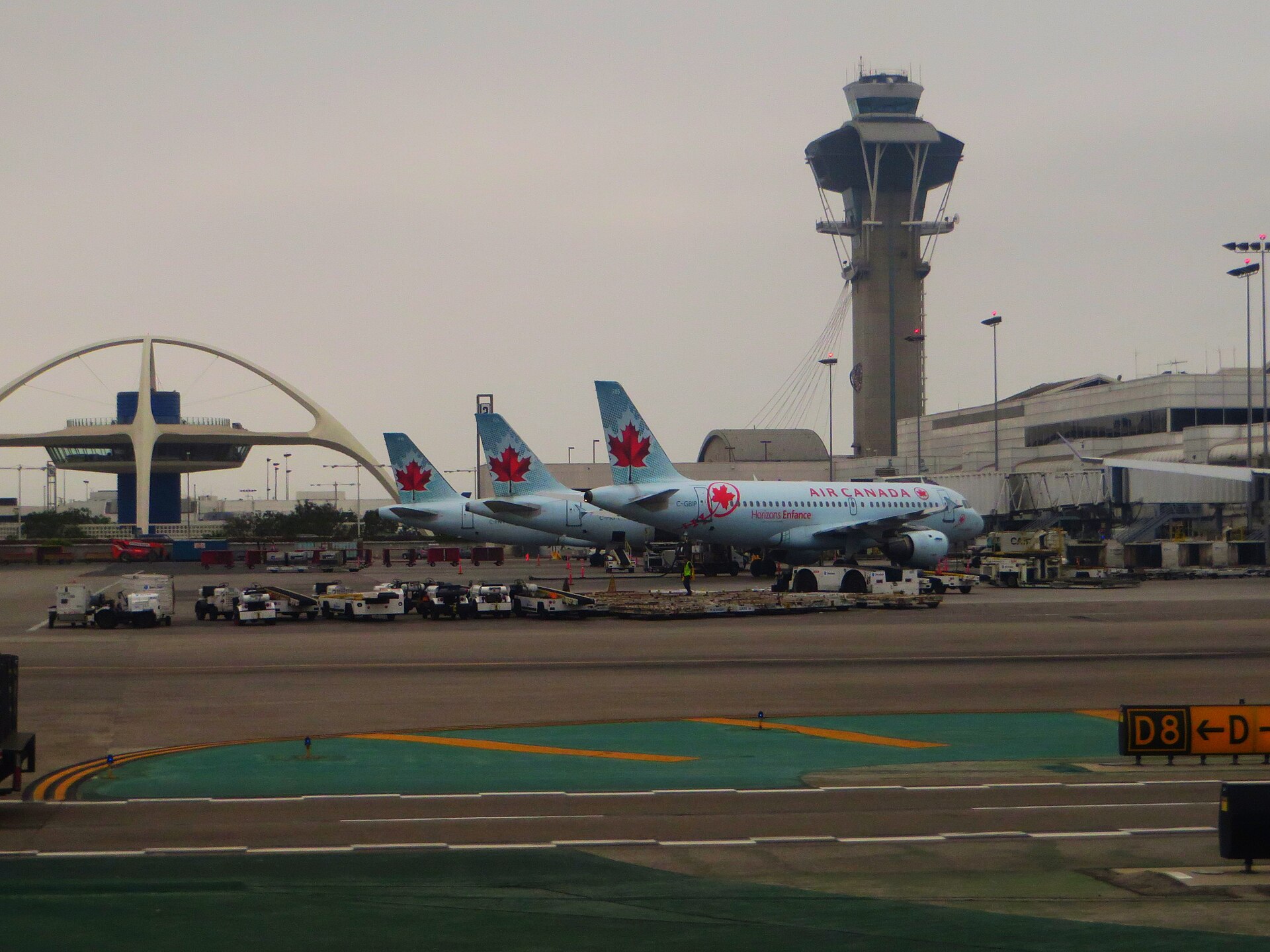 Air Canada aircraft parked at Los Angeles International Airport with the control tower behind.