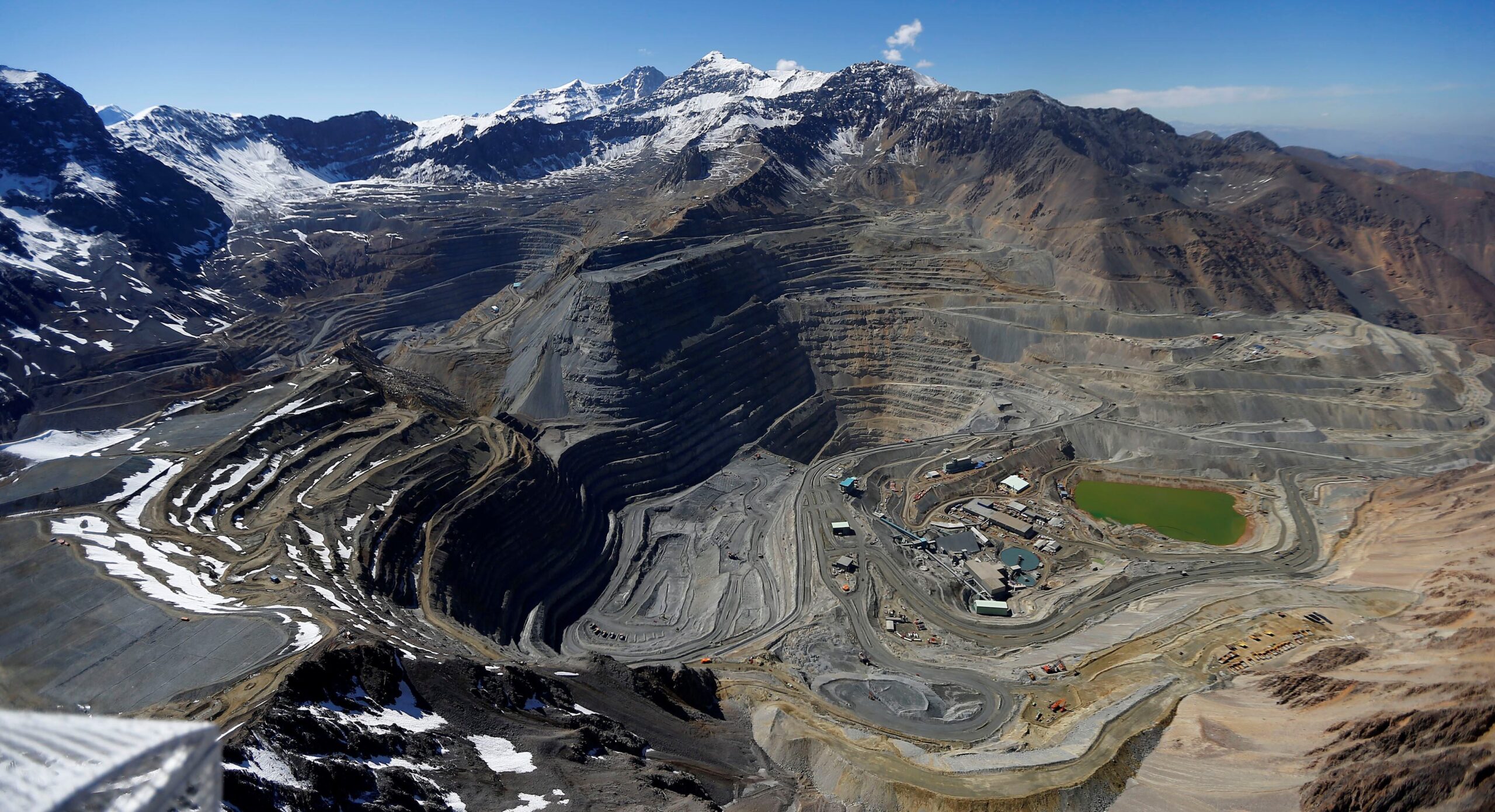 Colourful buildings of Sewell, the historic mining camp of the El Teniente copper mine, in snow below Andes peaks in Chile