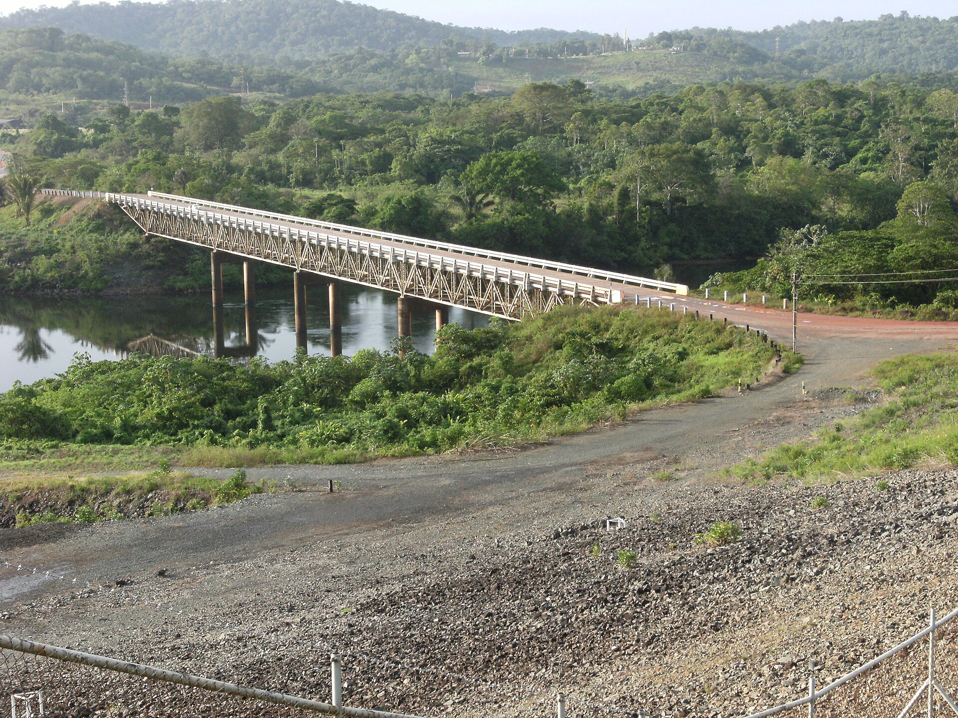 Modern bridge crossing the Suriname river with rainforest banks and blue water