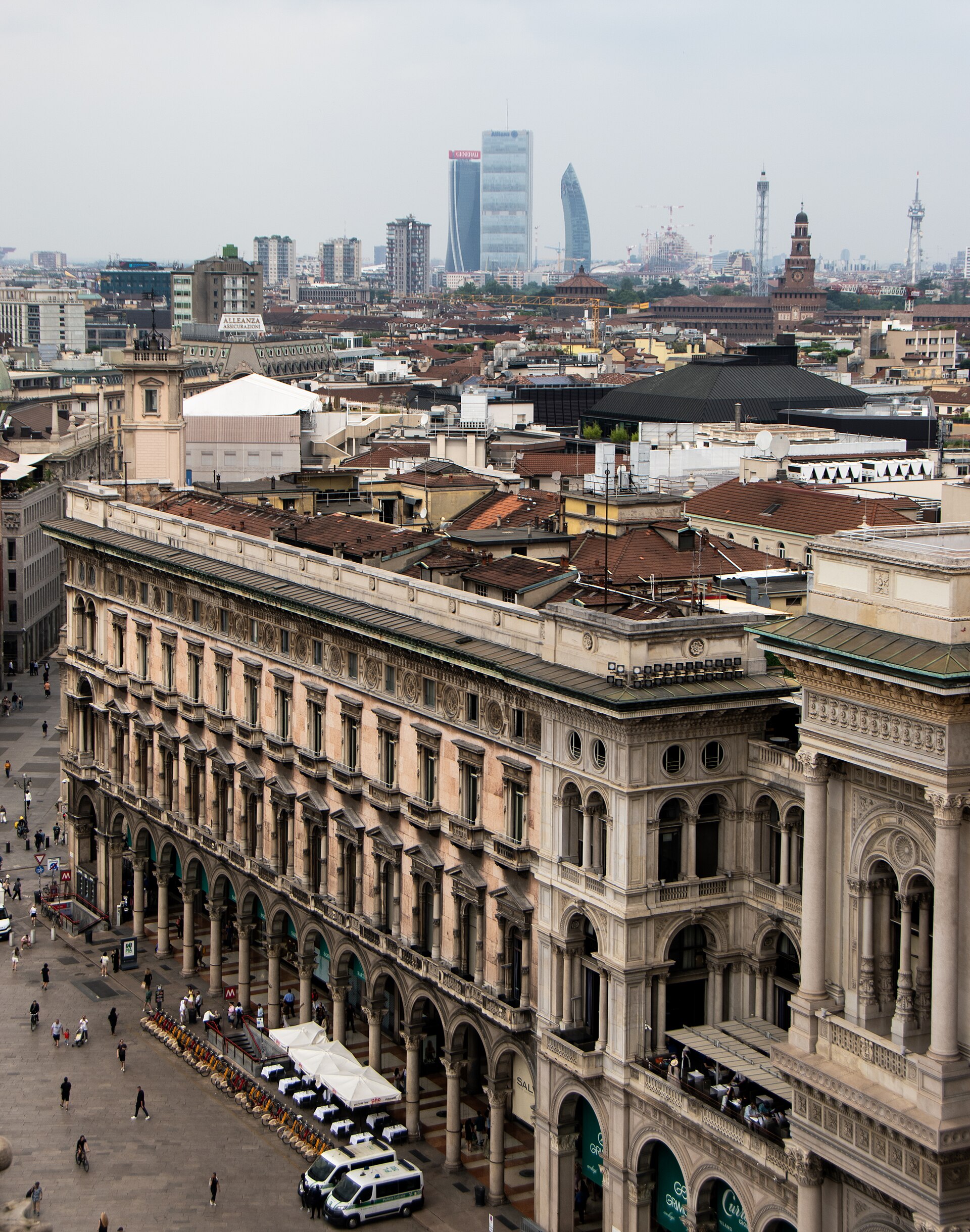 Aerial view of a building on Piazza Duomo with the skyline of Milan's CityLife district behind.