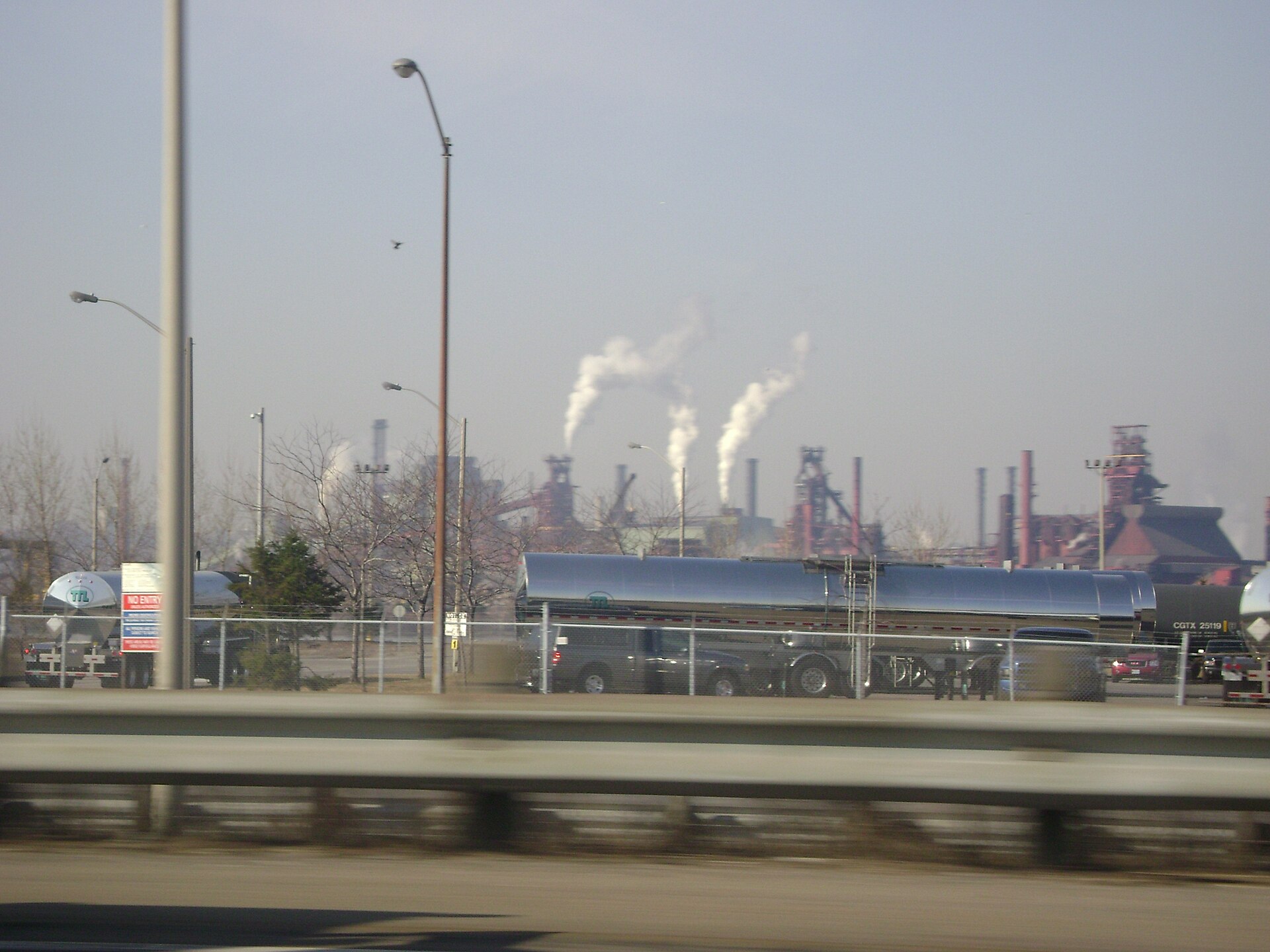 Smokestacks and blast furnaces of the Hamilton steel mills seen from a highway in Ontario.