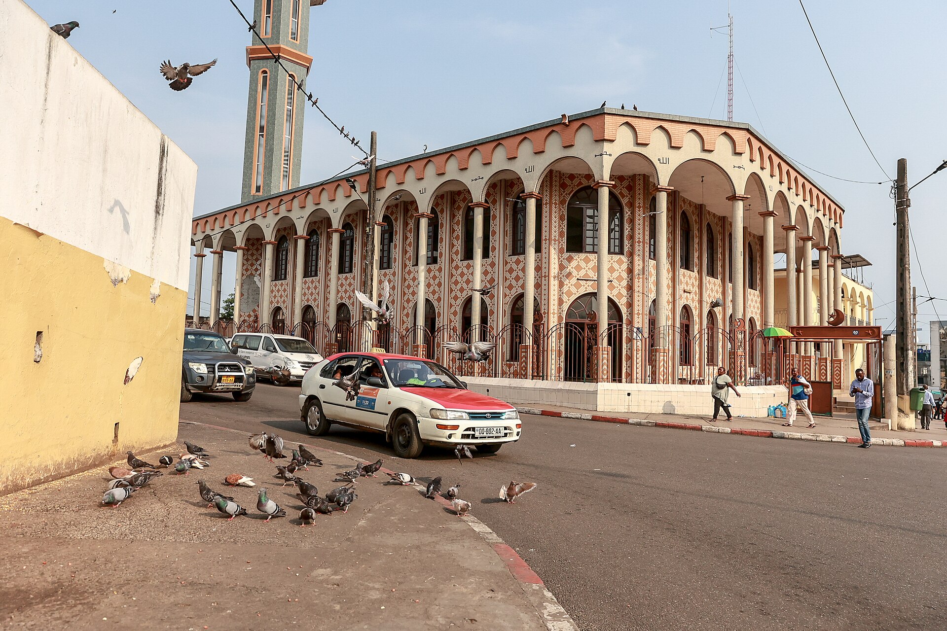 Taxi and pigeons on a street in front of the Central Mosque in Libreville, Gabon