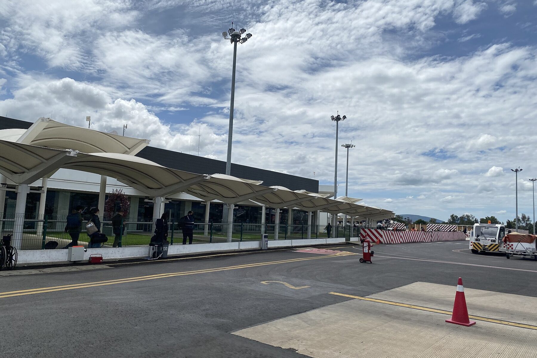 Exterior of Oaxaca International Airport terminal with canopy and apron on a cloudy day