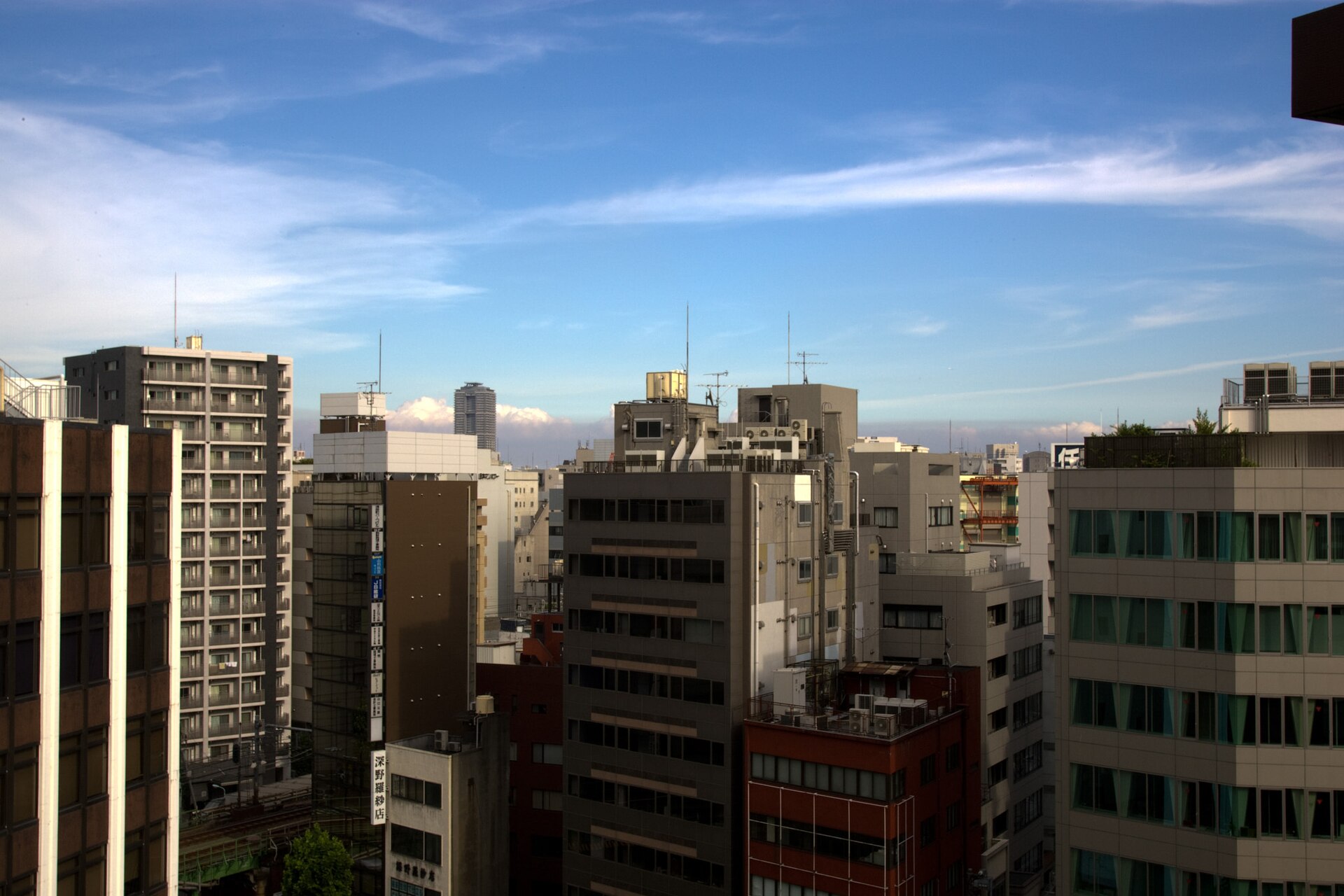 Apartment and office buildings under a blue sky in the Ueno area of Tokyo.
