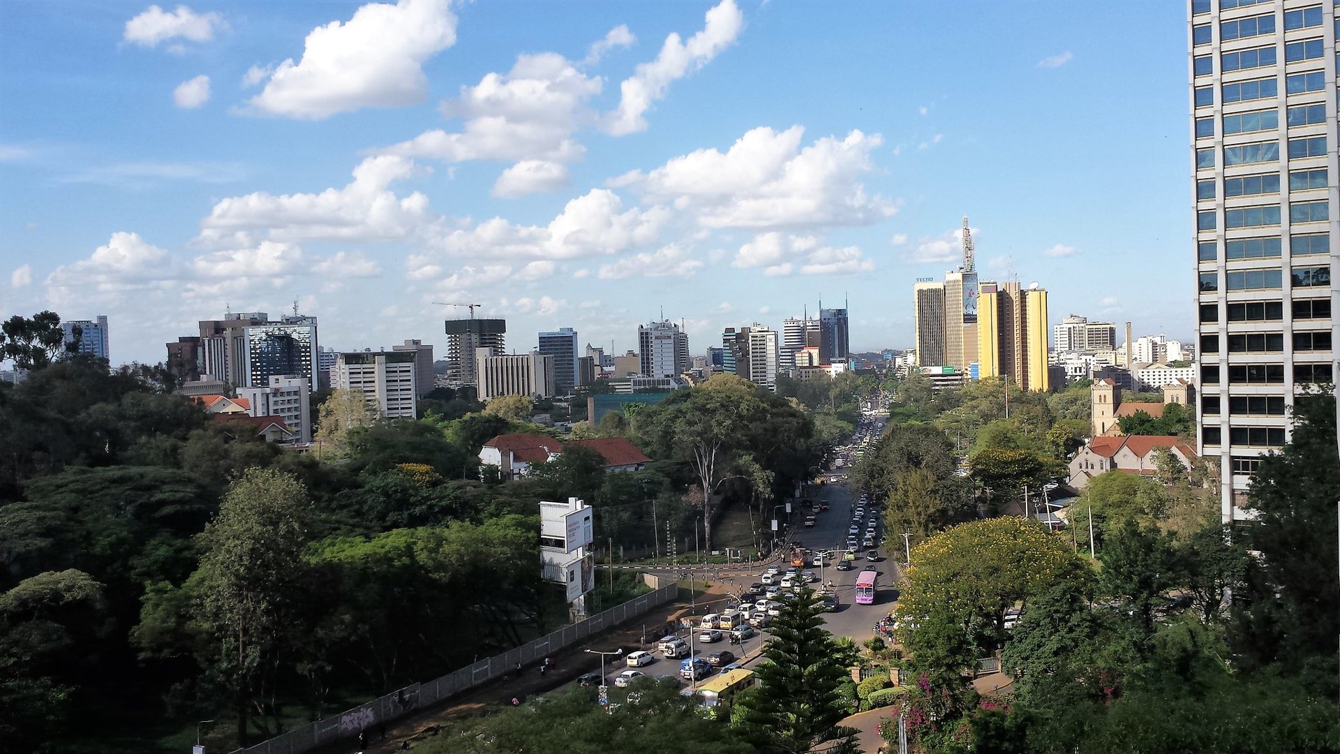 Office towers and a busy multi-lane road lined with trees in Nairobi, Kenya