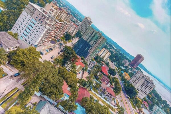 Aerial view of office towers, apartment blocks and palm trees in Kinshasa, with the Congo River on the horizon