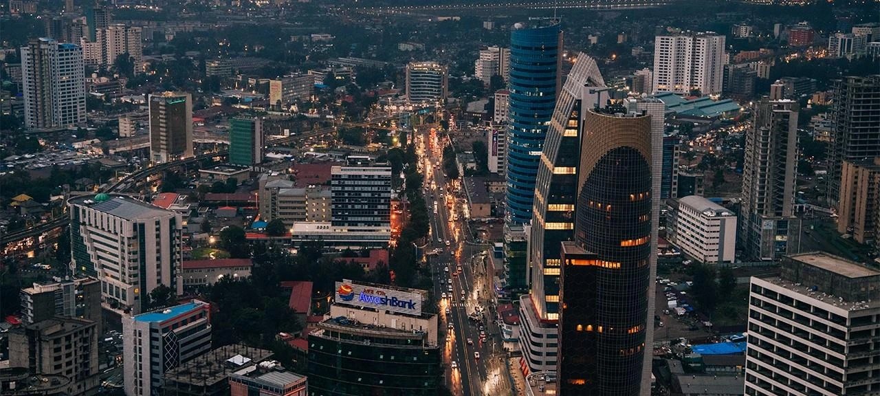 Addis Ababa city towers and a busy avenue at dusk seen from above