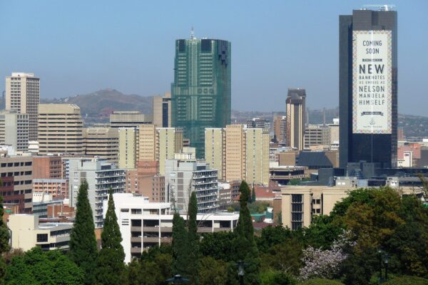 Pretoria city centre skyline with the dark South African Reserve Bank tower on the right carrying a large banknote banner