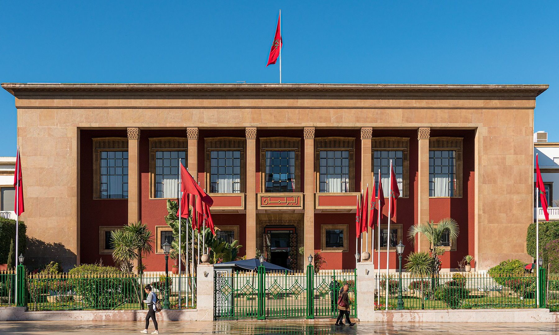 The Moroccan parliament building in Rabat with Moroccan flags out front.