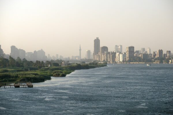 The Nile at Cairo with high-rise apartment blocks and a minaret on the far bank in morning haze