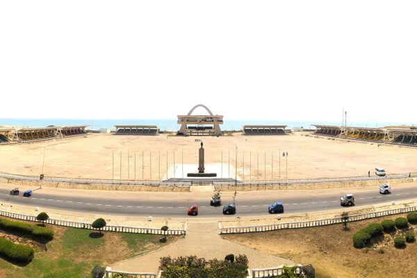 Wide view of Black Star Square in Accra, with the independence arch at the centre of a large open parade ground and the sea behind