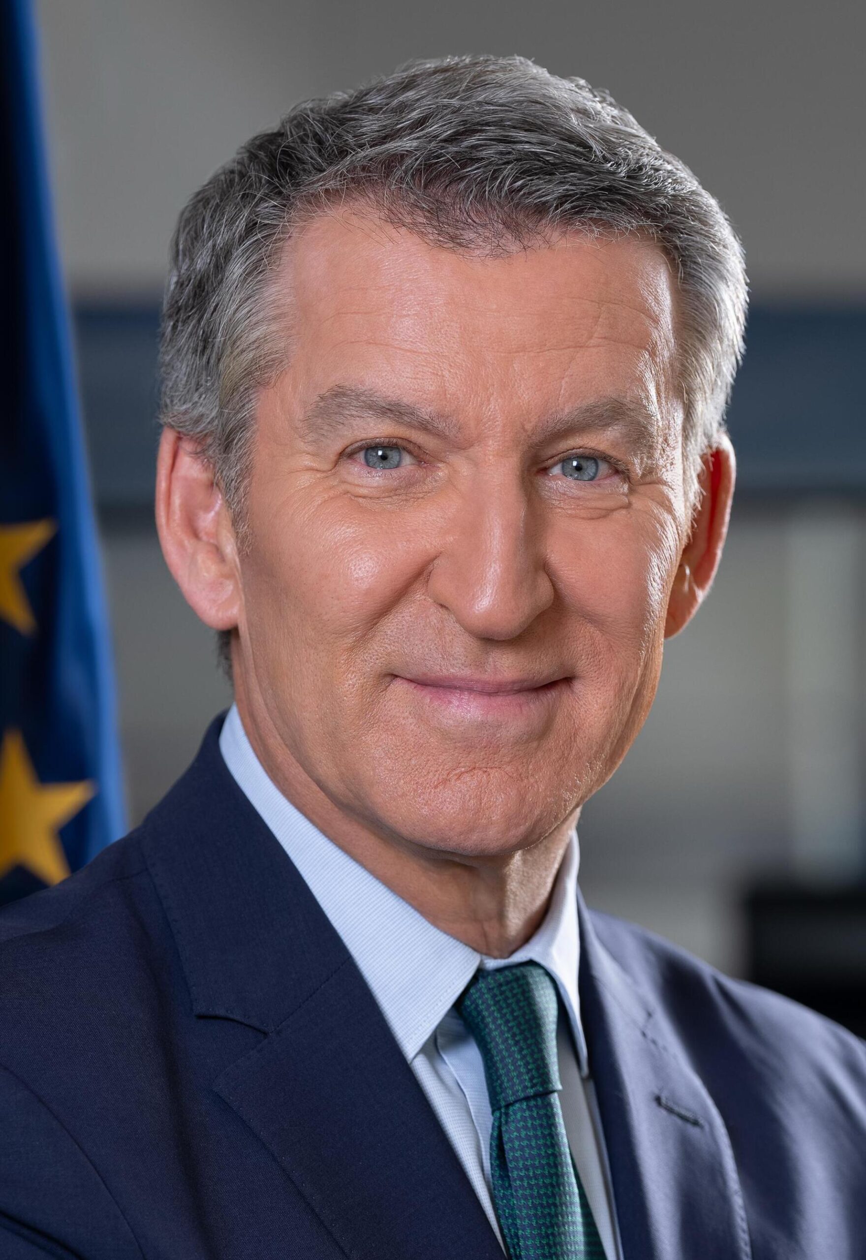 Official portrait of Alberto Núñez Feijóo in a dark suit in front of the EU flag