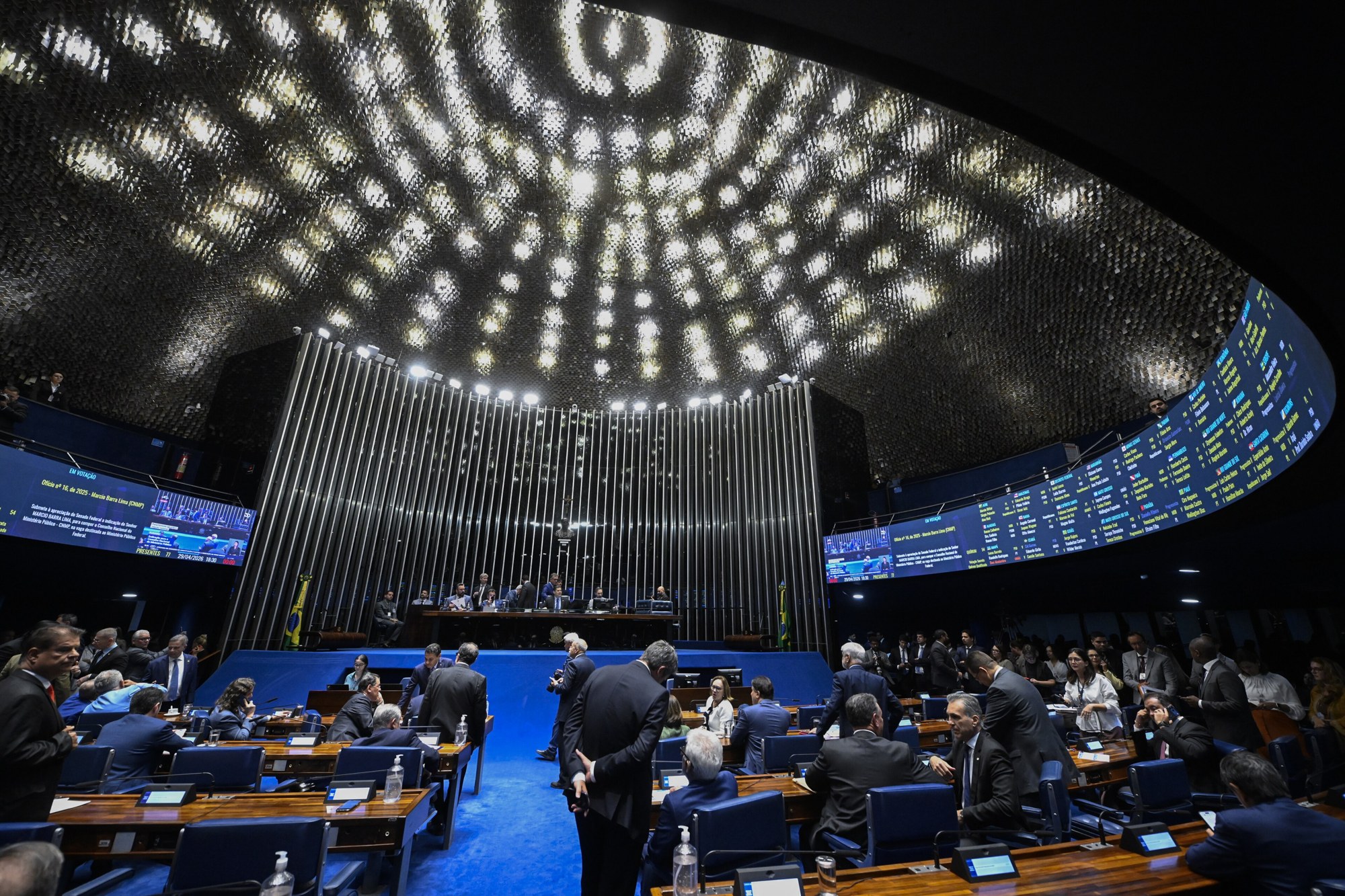 The main floor of the Federal Senate plenary in Brasília during a session, with senators at their desks beneath the illuminated ceiling