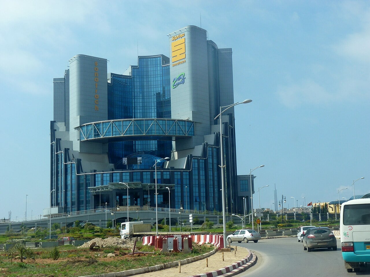 Glass headquarters of Algerian energy company Sonatrach in Oran, with a street and cars in the foreground