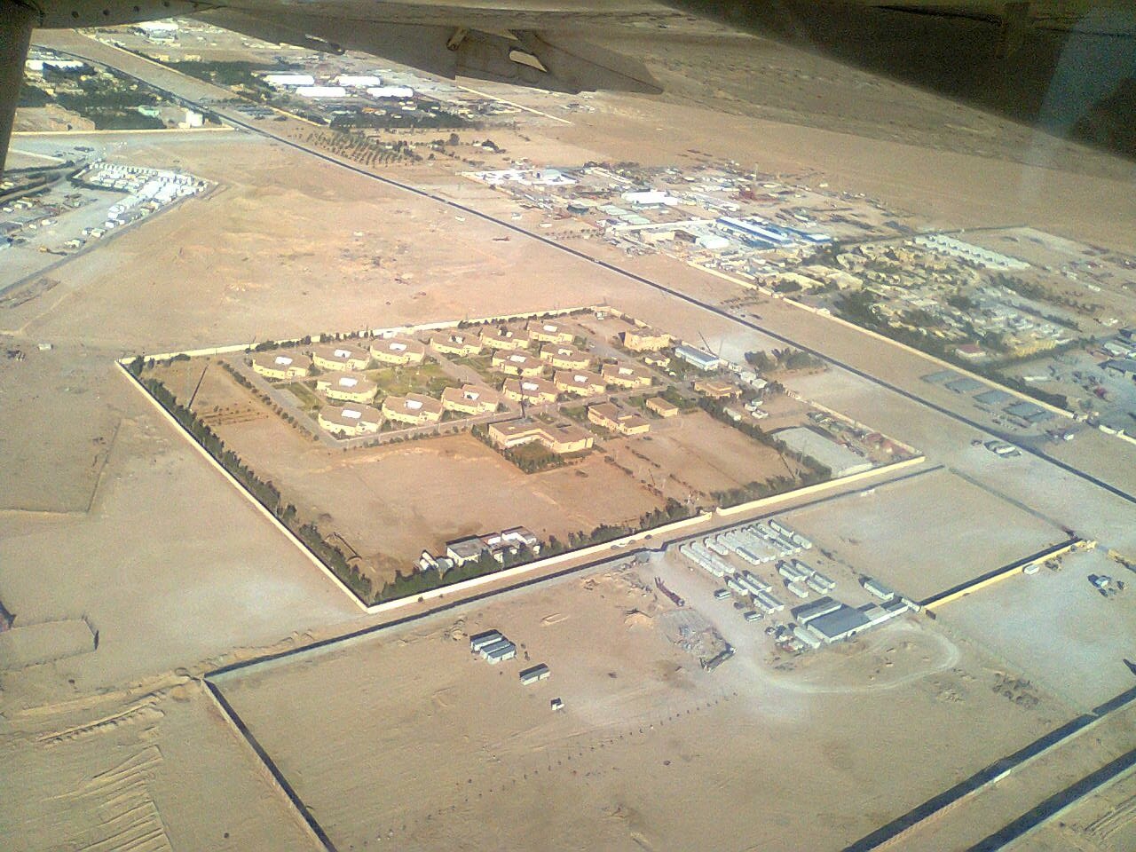 Aerial view of a walled housing compound and industrial yards in the desert at Hassi Messaoud, Algeria