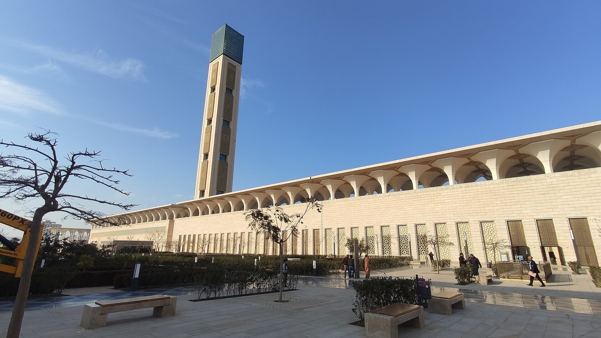 Minaret and arcaded wall of the Great Mosque of Algiers under a blue sky
