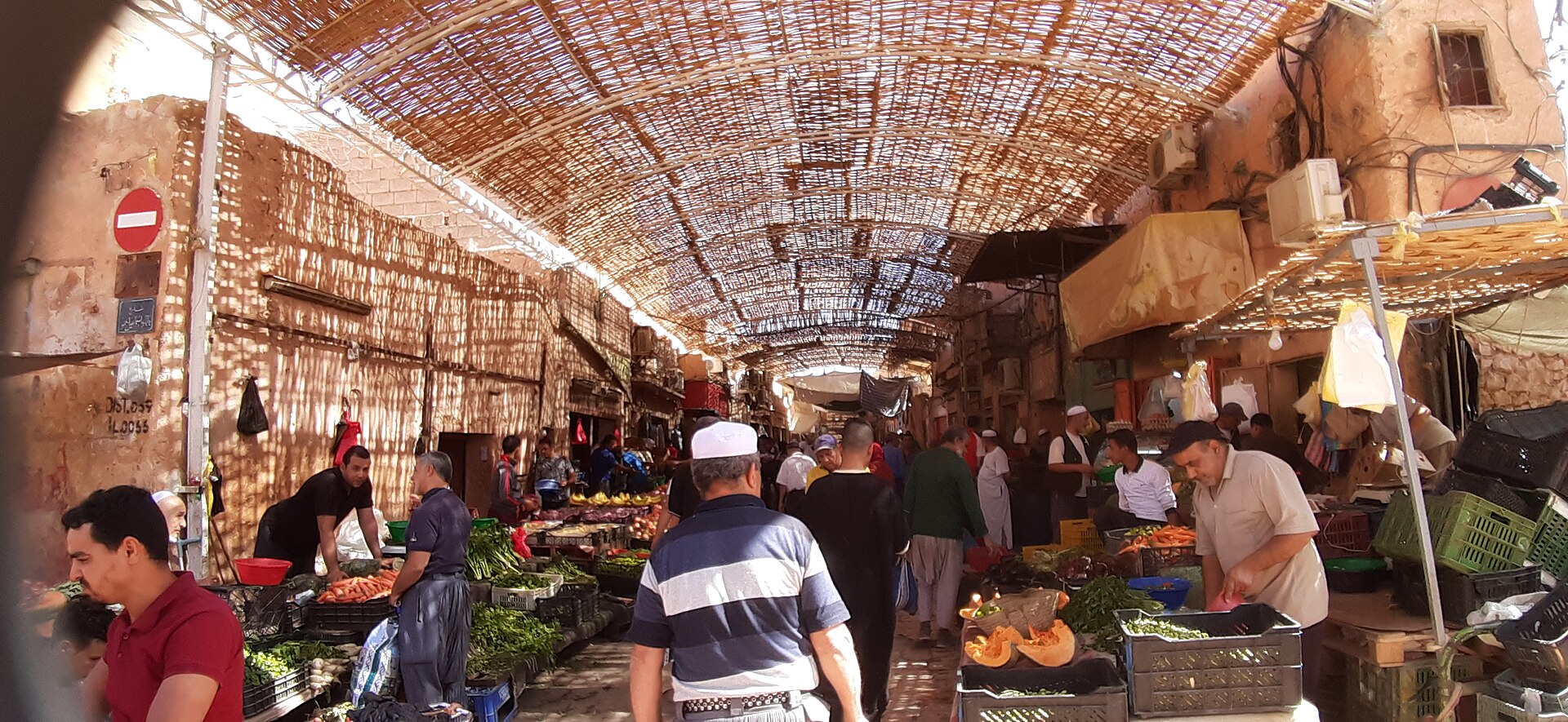 Shoppers and vegetable sellers under a reed-covered street in the market of Ghardaia, Algeria
