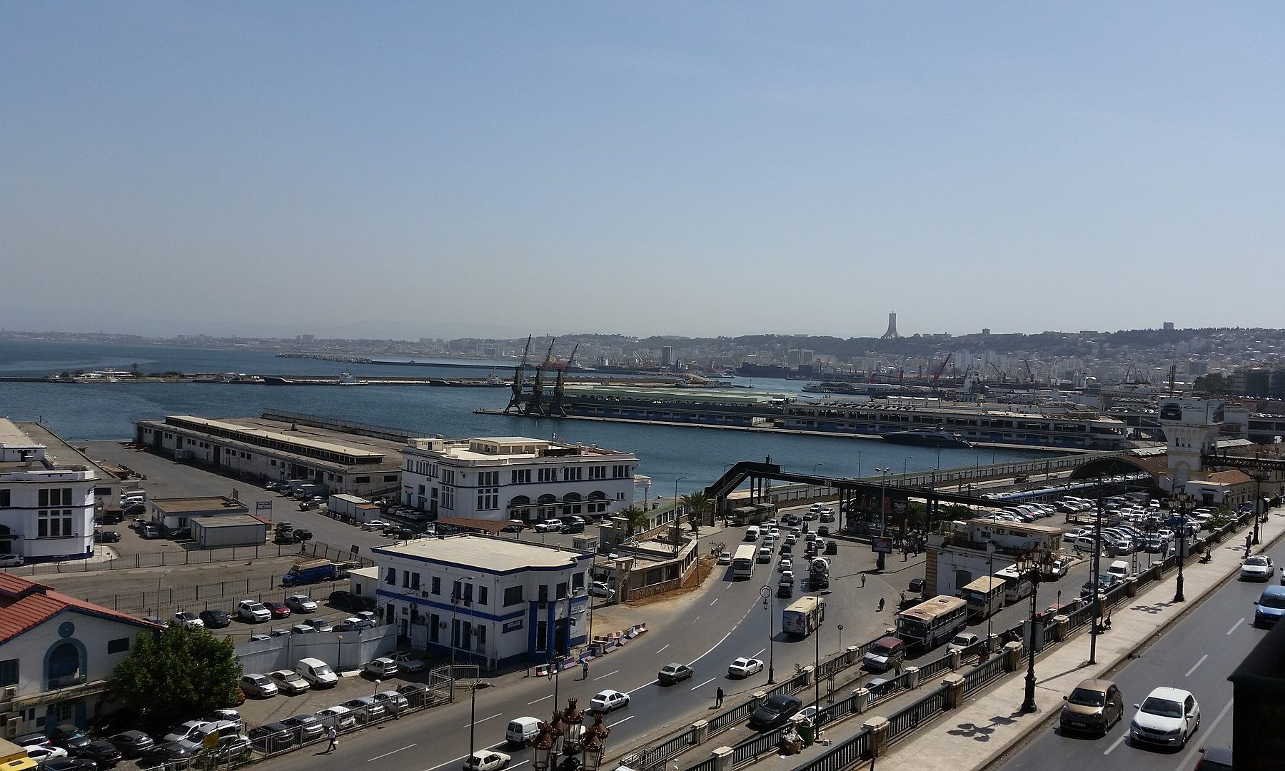 The Port of Algiers with quays, cranes and the waterfront road busy with traffic, seen from above