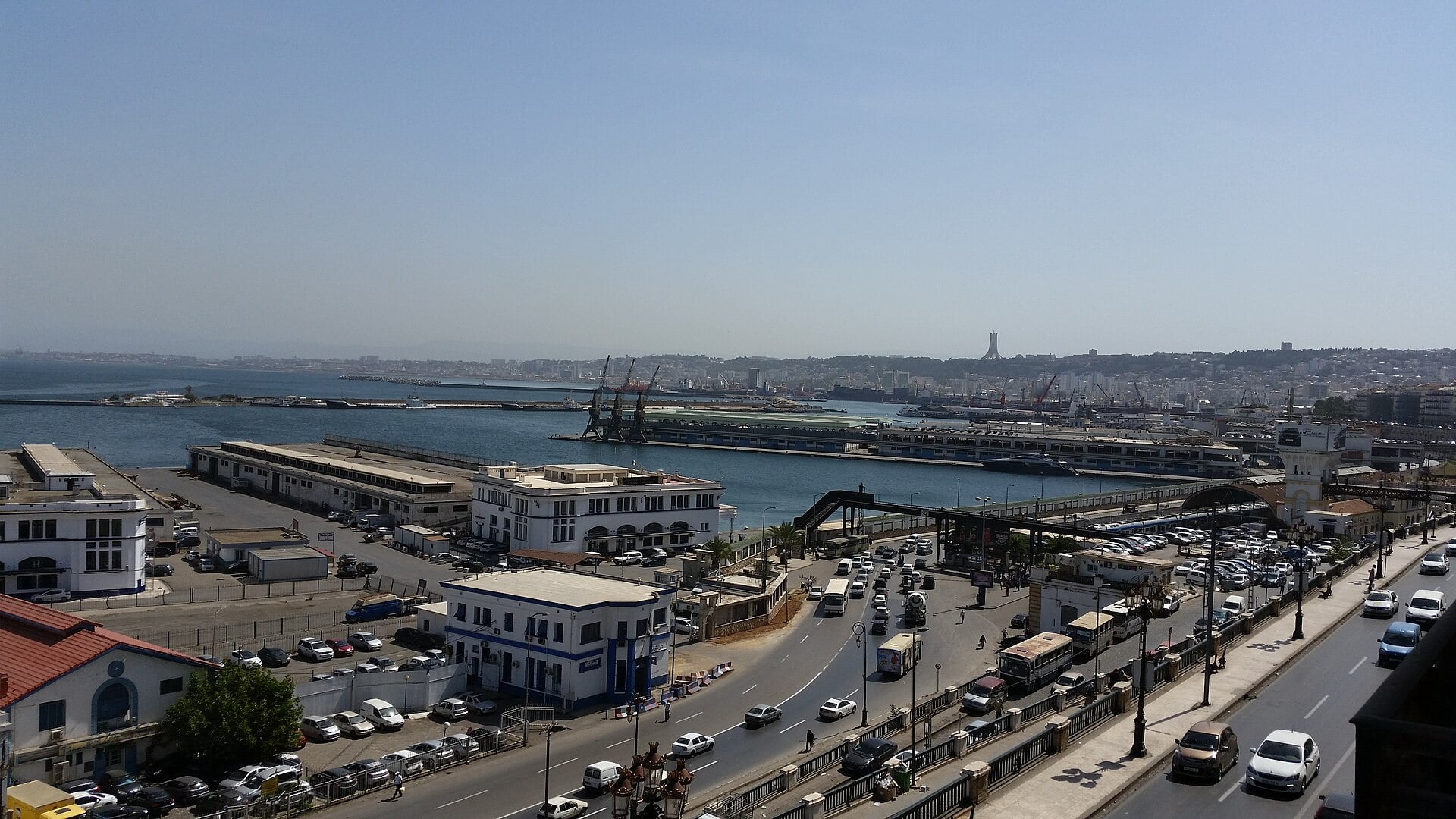 The Port of Algiers with quays, cranes and the waterfront road busy with traffic, seen from above
