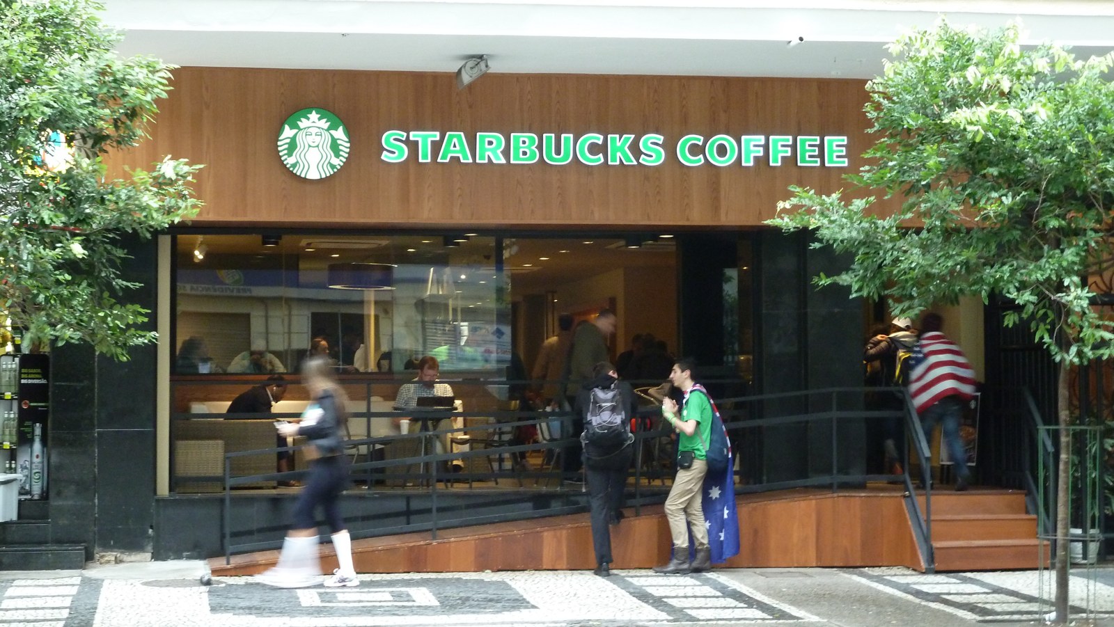 A Starbucks Coffee cafe on a city street with customers outside