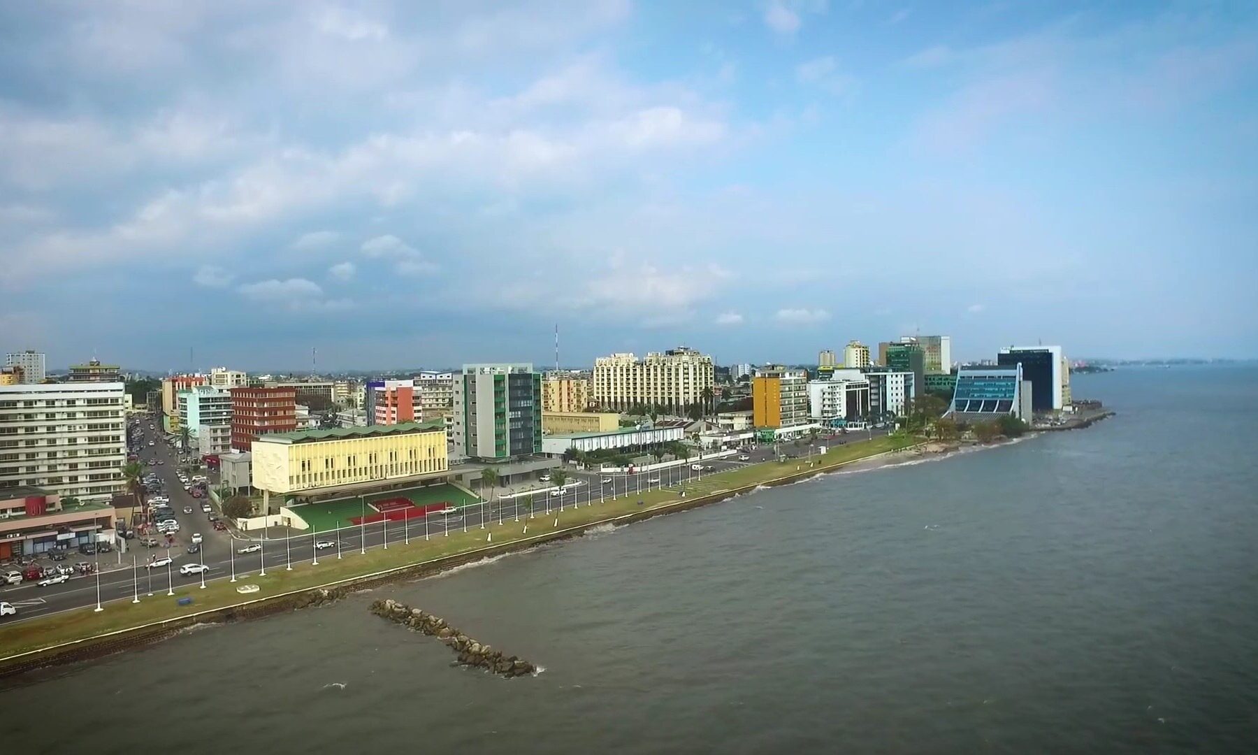 Aerial view of the Libreville seafront in Gabon with office buildings along the coast road and the sea on the right