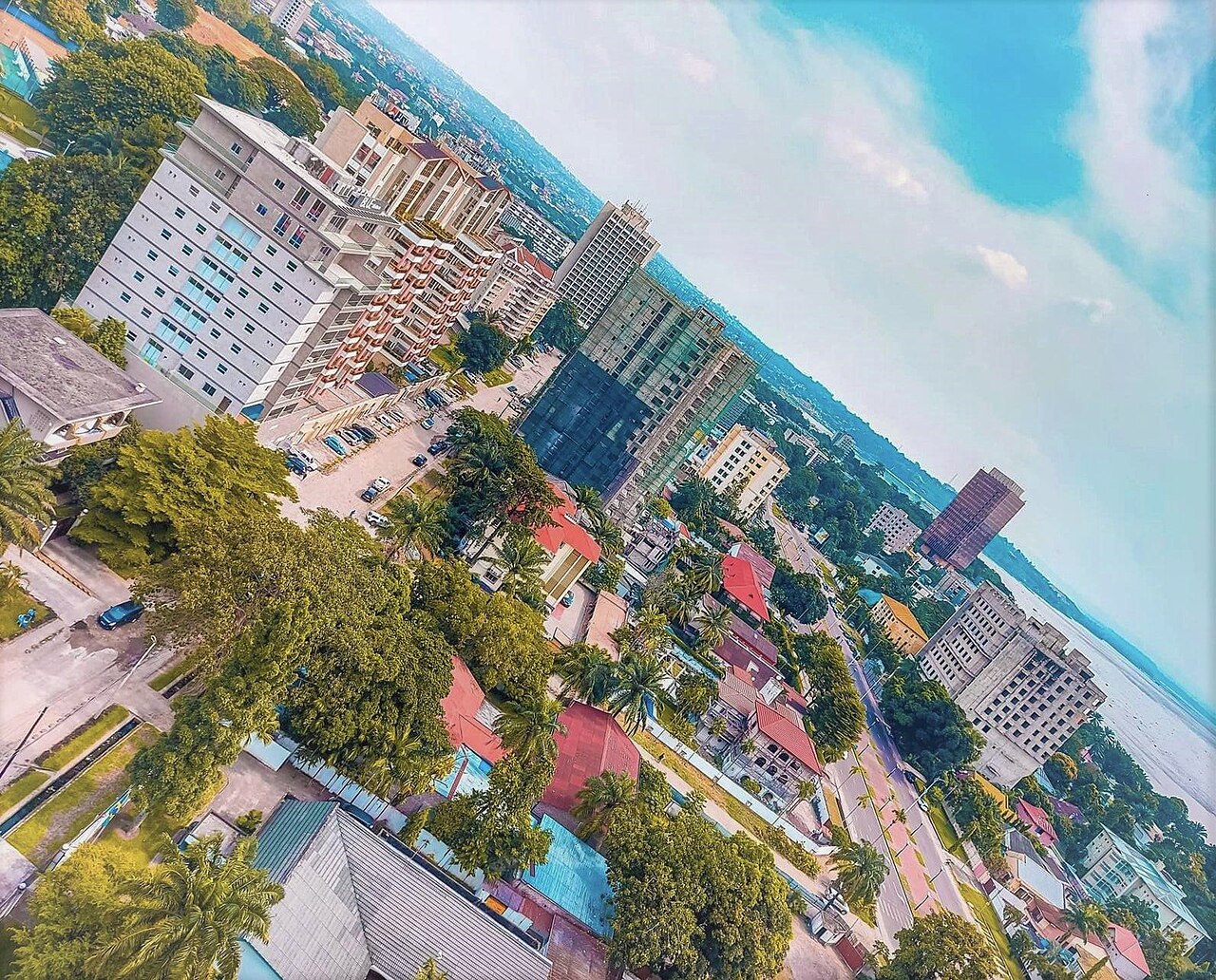 Aerial view of office towers, apartment blocks and palm trees in Kinshasa, with the Congo River on the horizon