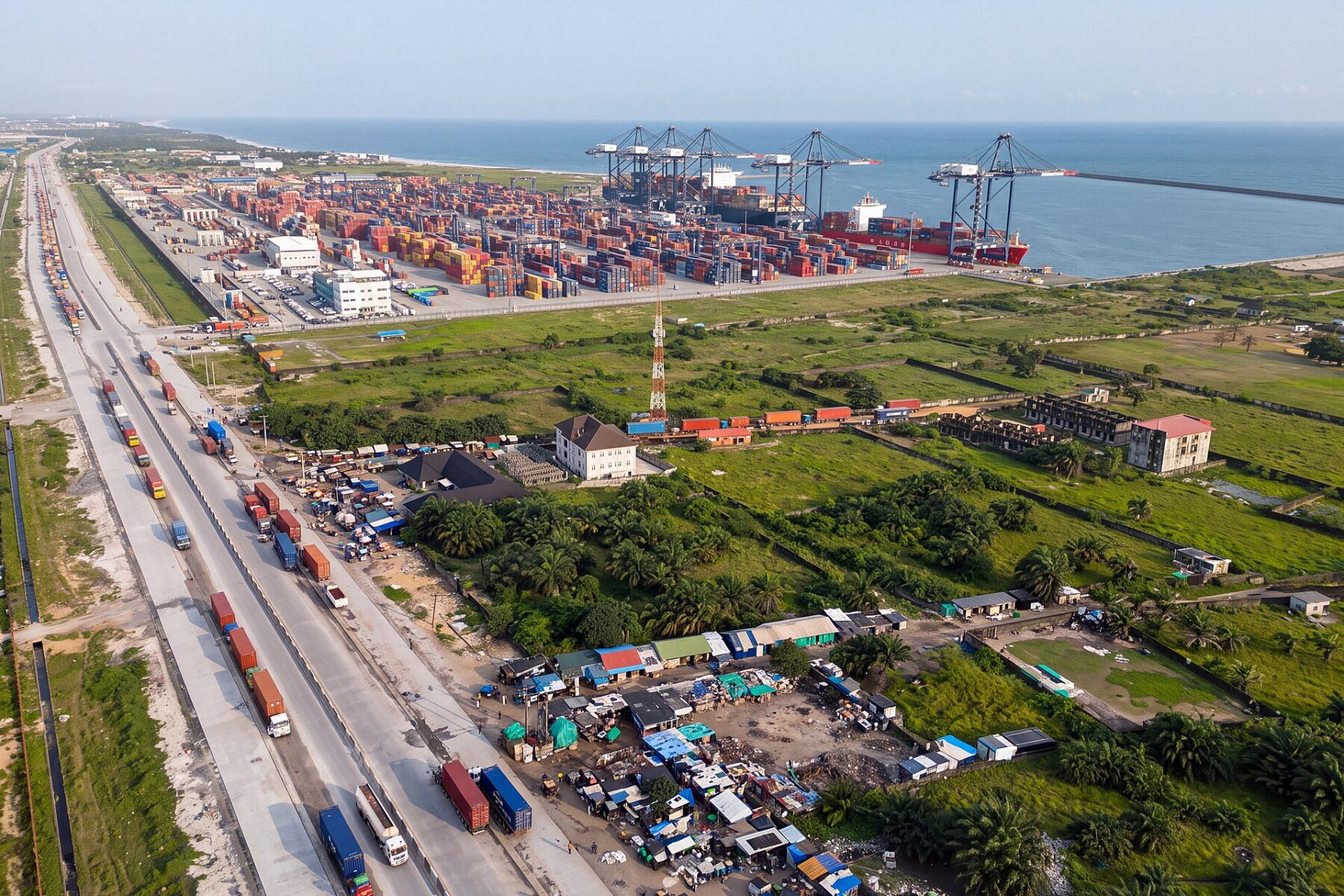 Aerial view of the Lekki Deep Sea Port east of Lagos with ship-to-shore cranes, a container ship at the quay, stacked containers and queuing trucks