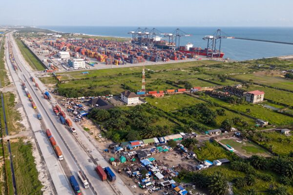 Aerial view of the Lekki Deep Sea Port east of Lagos with ship-to-shore cranes, a container ship at the quay, stacked containers and queuing trucks