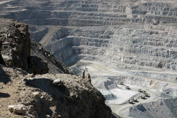 Terraced open pit of the Rossing uranium mine in Namibia's Erongo region with haul trucks on the pit floor