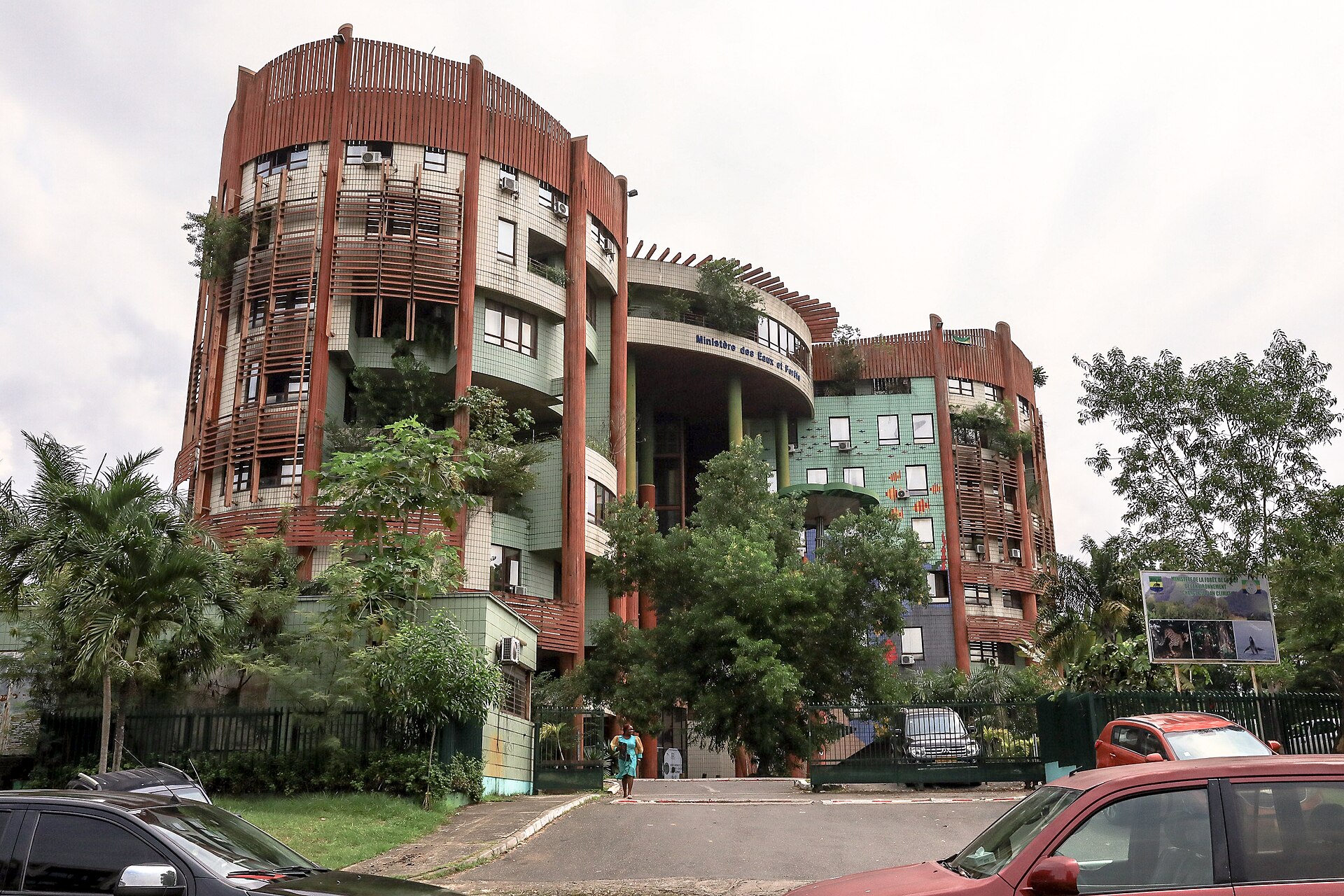 A government building with rust-coloured balconies and trees in Libreville, Gabon