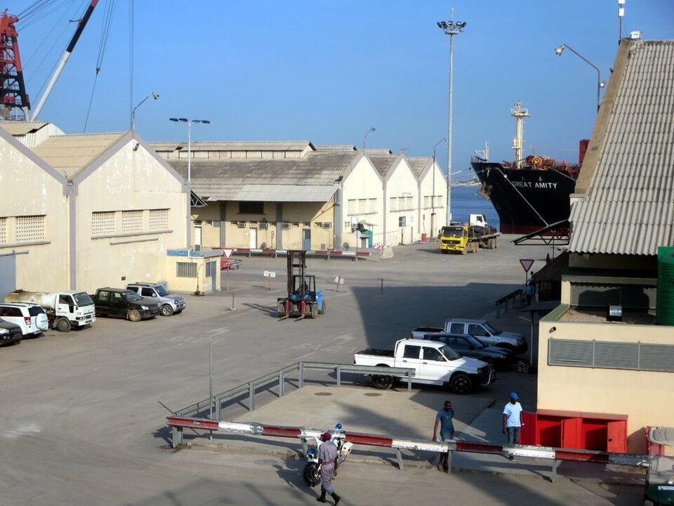 Warehouses, trucks and a ship alongside a quay in the port of Luanda in Angola